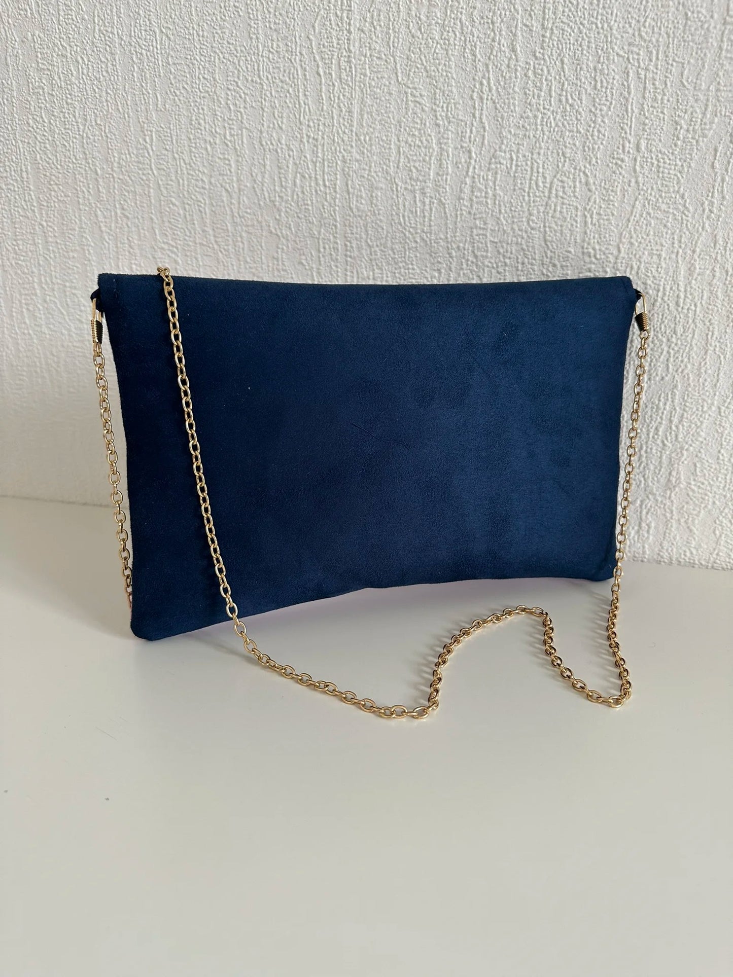 Le dos du sac pochette Isa bleu marine violet et doré avec sa chainette dorée amovible.
