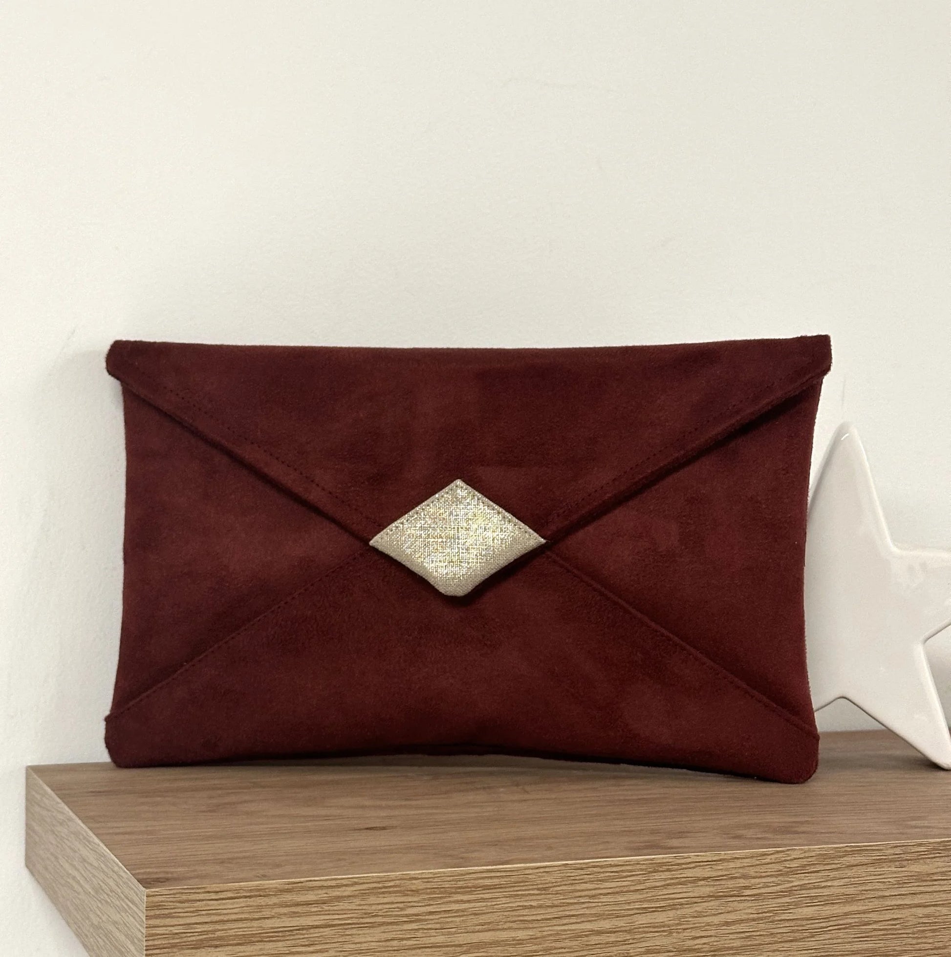 Le sac pochette Isa bordeaux et lin doré, sans chainette.