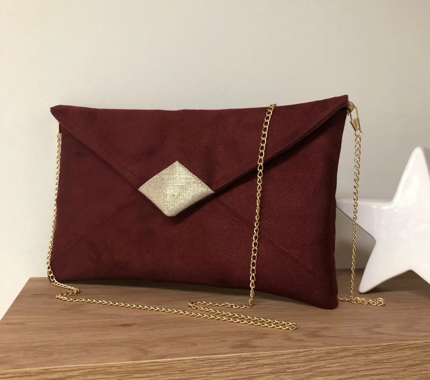 Le sac pochette Isa bordeaux et lin doré, avec chainette amovible, vue de face.