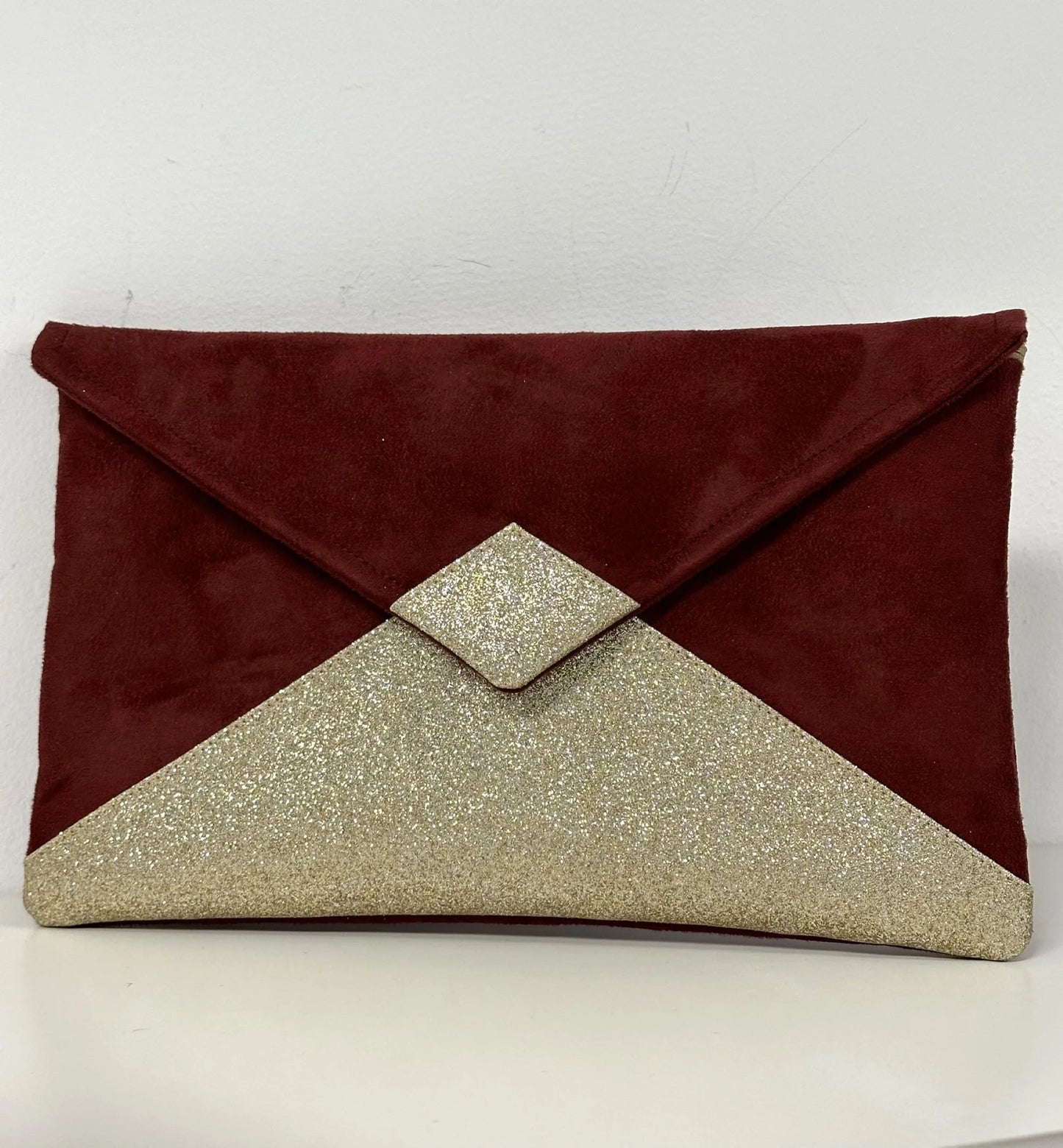 Le sac pochette Isa bordeaux à paillettes dorées, sans chainette.