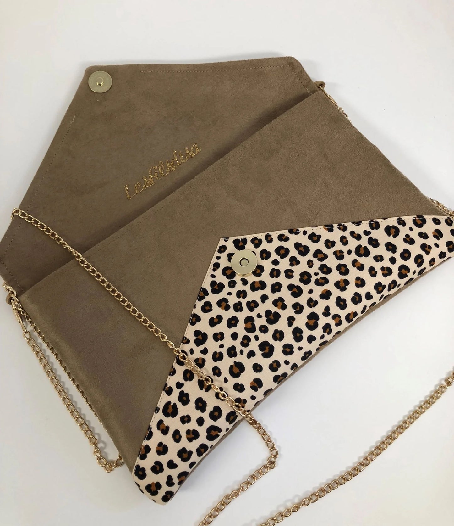 Le sac pochette Isa camel à motif animal et paillettes dorées, avec sa chainette amovible, ouvert.