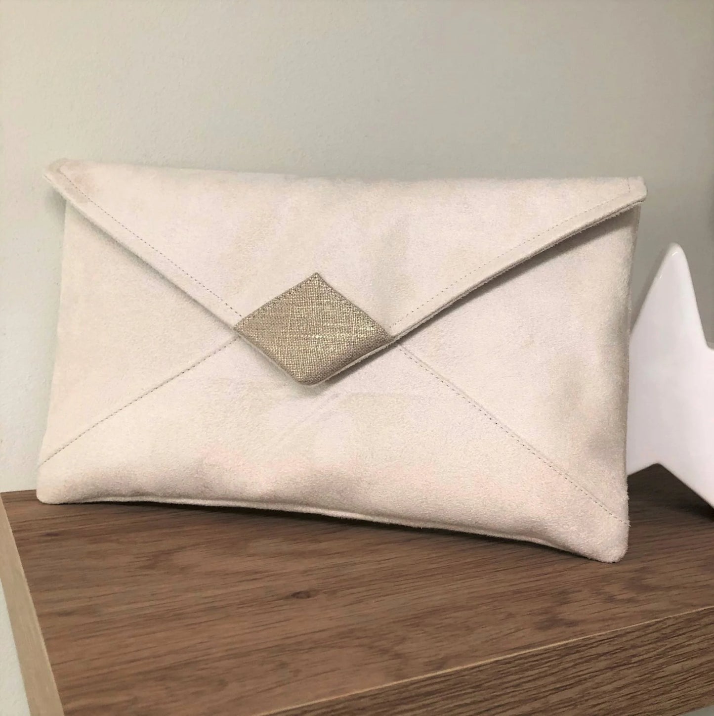 Le sac pochette Isa écru et lin doré sans chainette dorée.