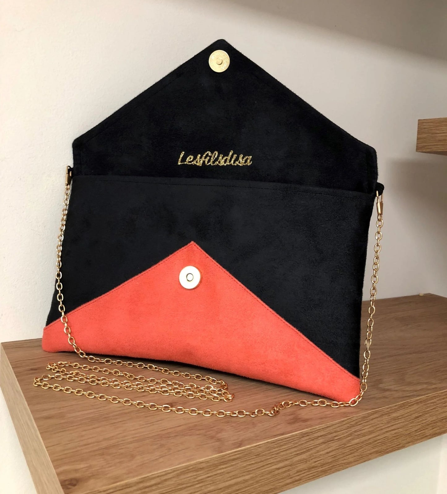 Le sac pochette Isa noir et corail à paillettes dorées, ouvert.