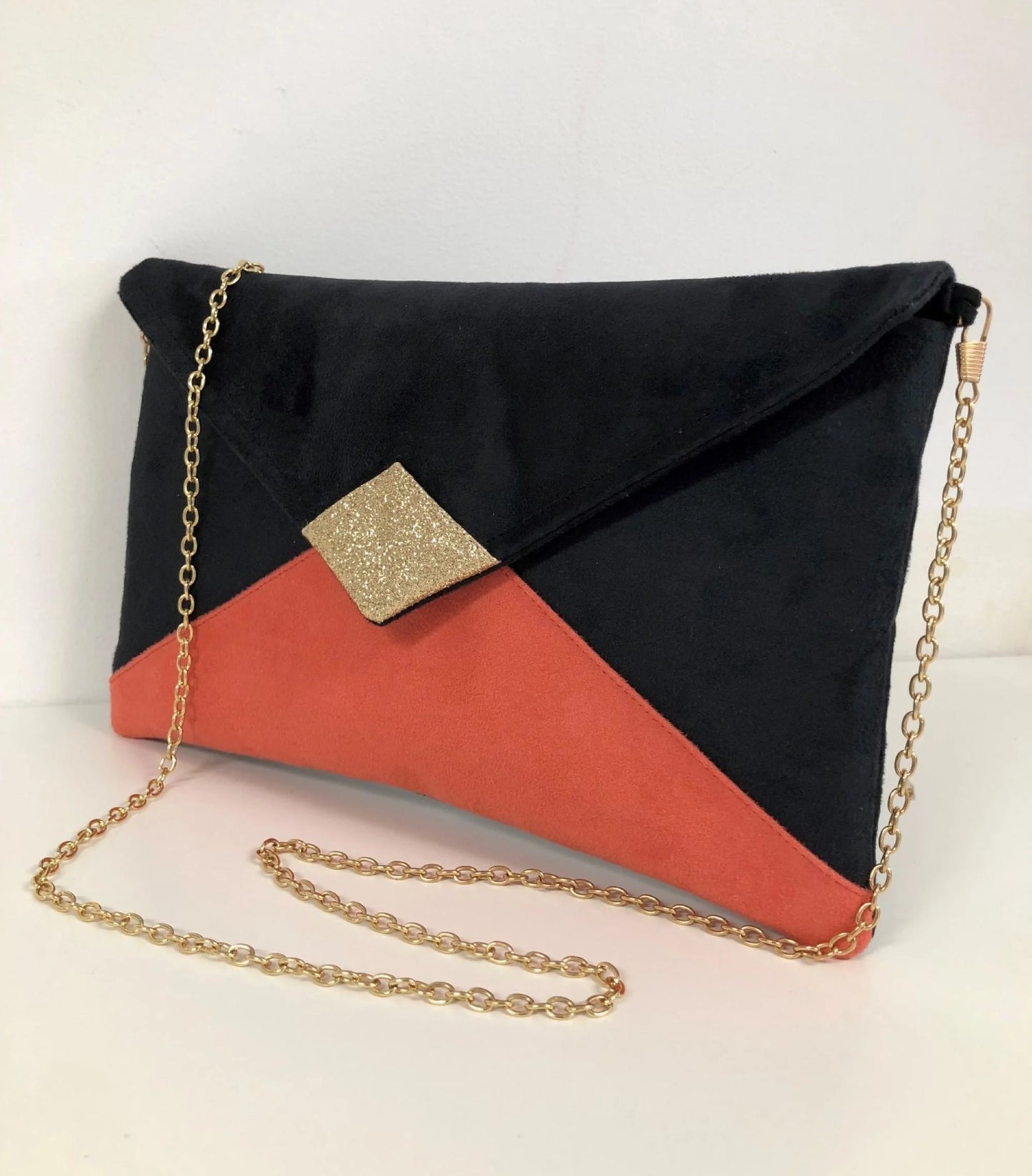 le sac pochette Isa noir et corail à paillettes dorées, vue de face.