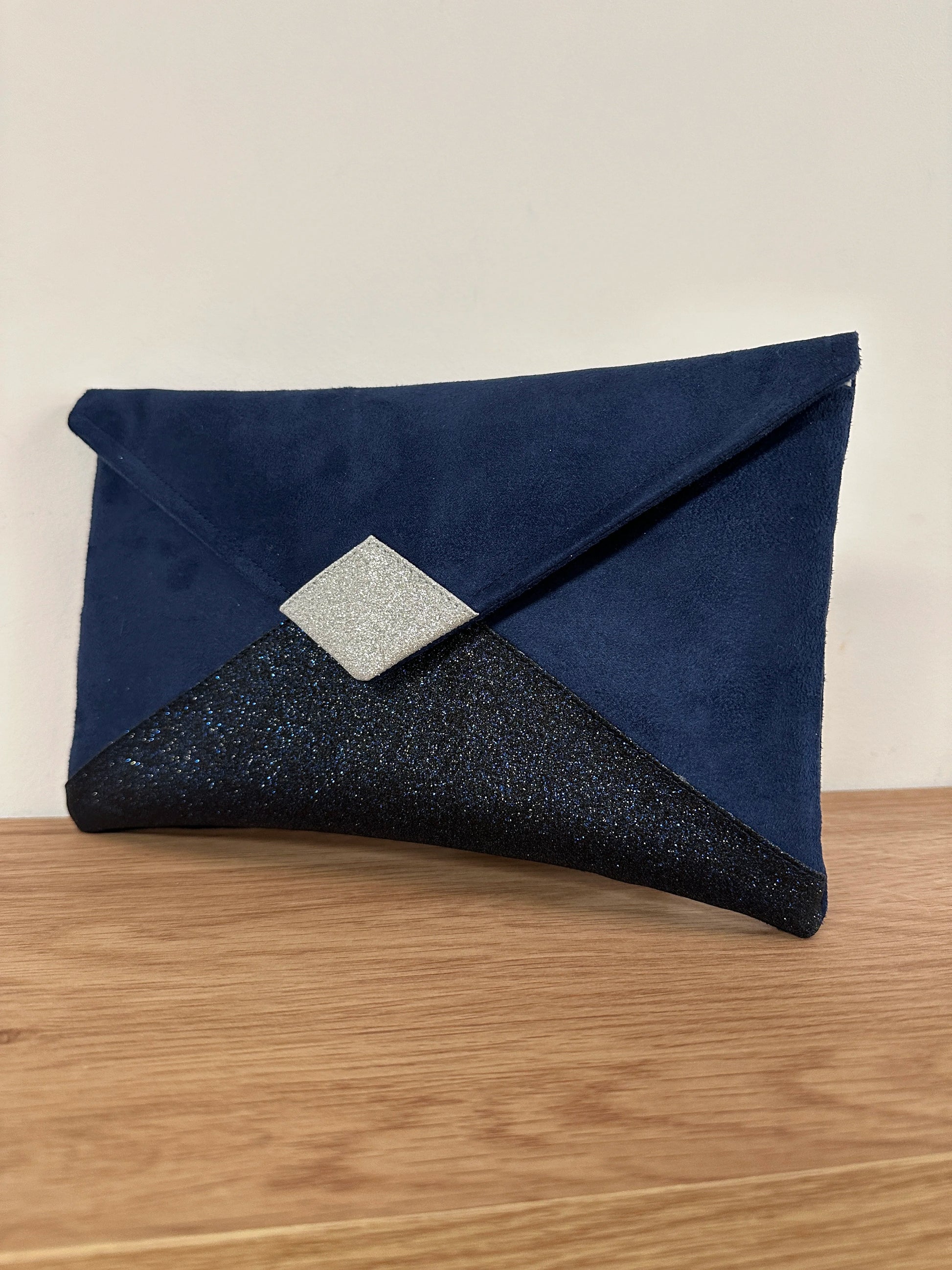Le Le sac pochette Isa à paillettes bleu marine et argentées, sans chainette.