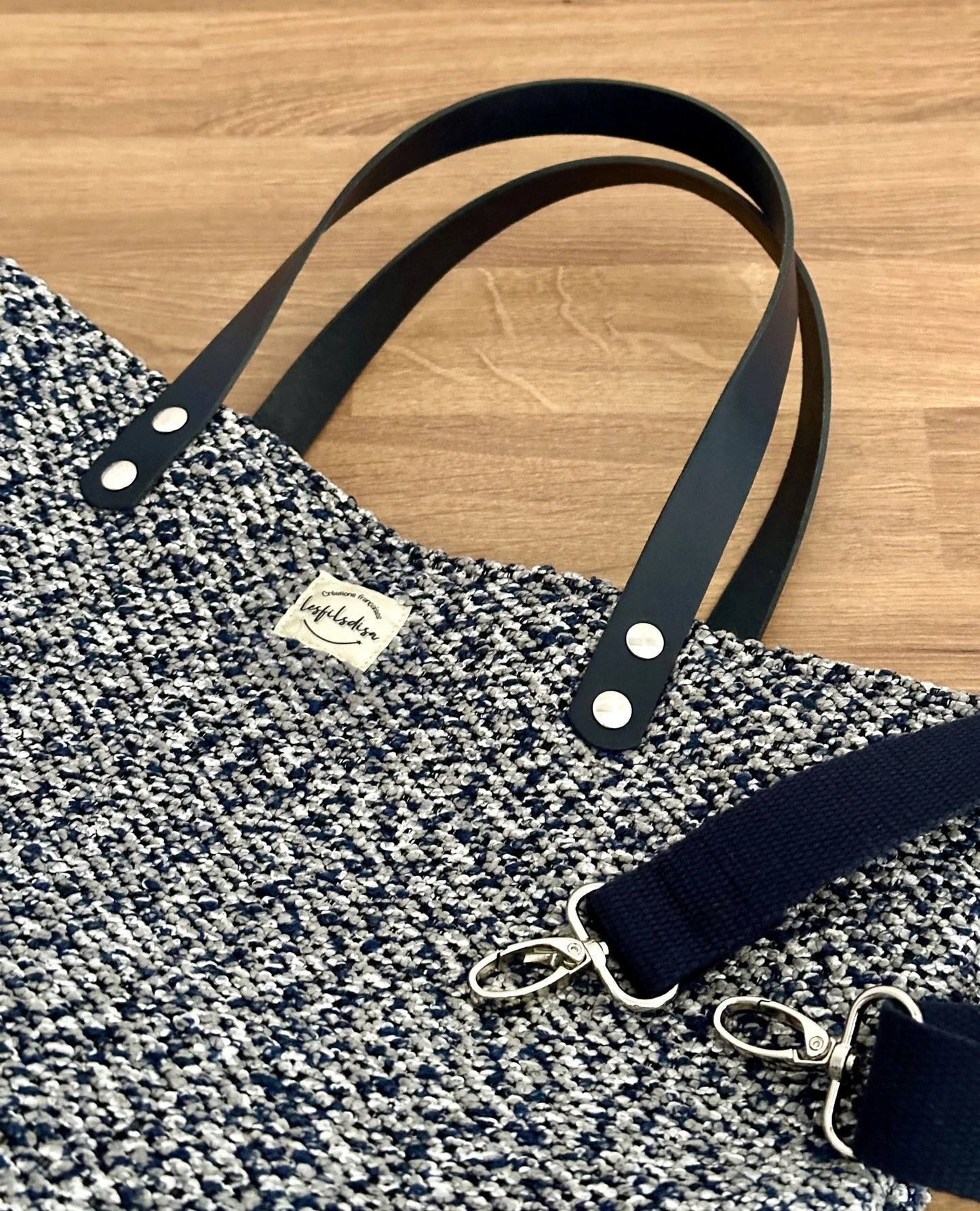 Les anses en cuir bleu marine du sac shopper bleu chiné.