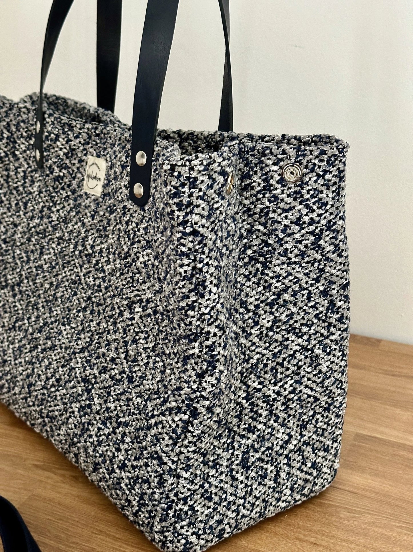 Vue latérale du sac shopper bleu chiné, avec bouton pression.