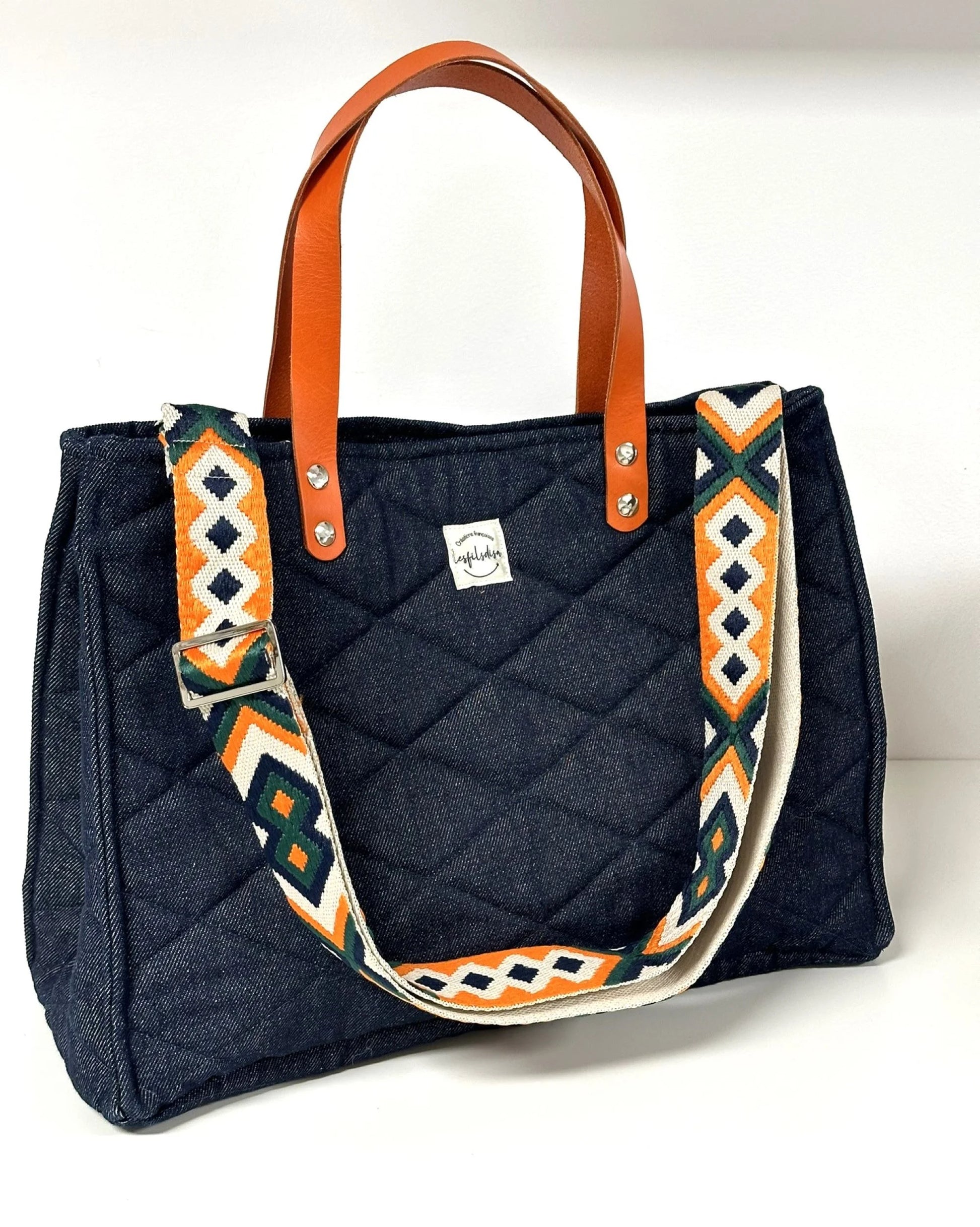 Le sac Shopper en denim et cuir orange, avec sa bandoulière amovible.