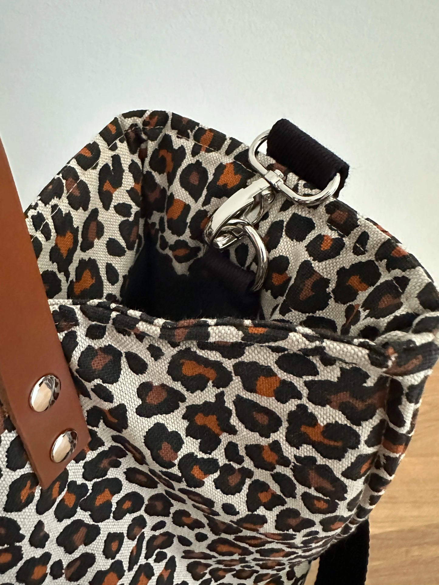 Le système de fixation intérieure pour l'anse bandoulière du sac shopper léopard.