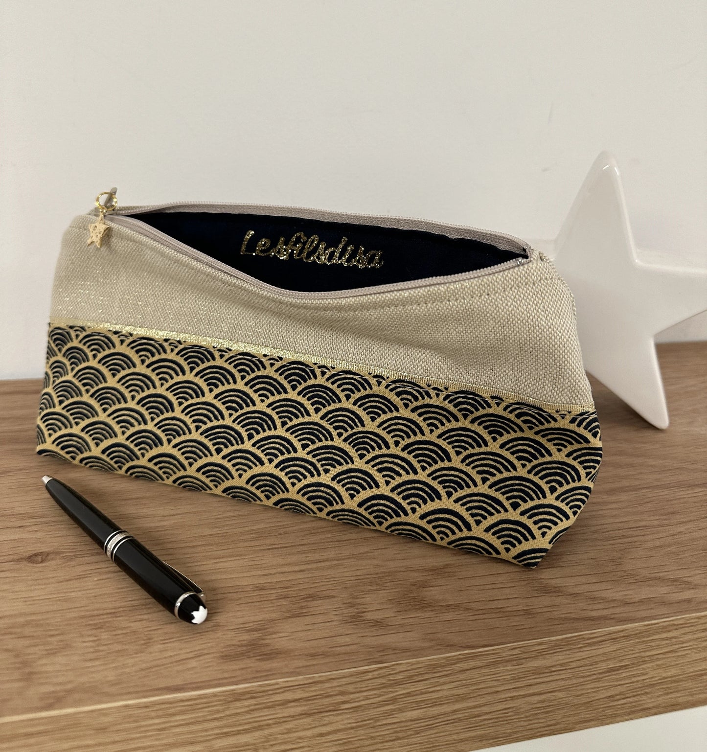 La trousse à stylos en tissu japonais Seigaiha bleu marine et doré, ouverte.