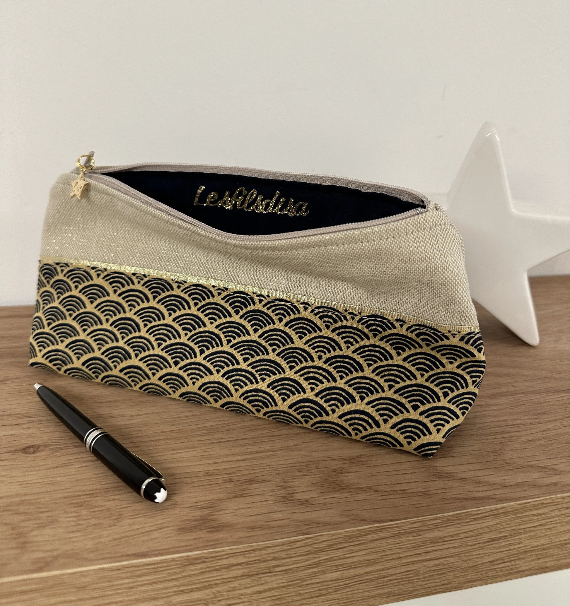 La trousse à stylos en tissu japonais Seigaiha bleu marine et doré, ouverte.