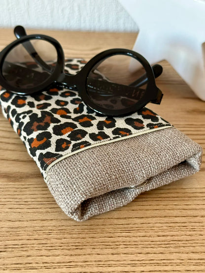 Le fermoir magnétique extra-plat de l'étui à lunettes léopard en lin beige.