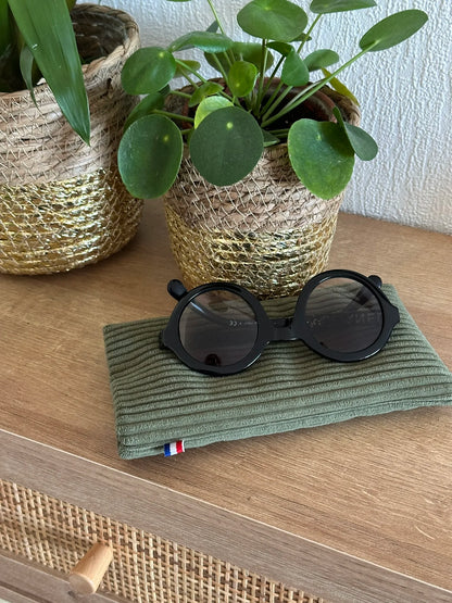 Présentation de l'étui à lunettes en velours cotelé vert armée avec des lunettes de soleil.