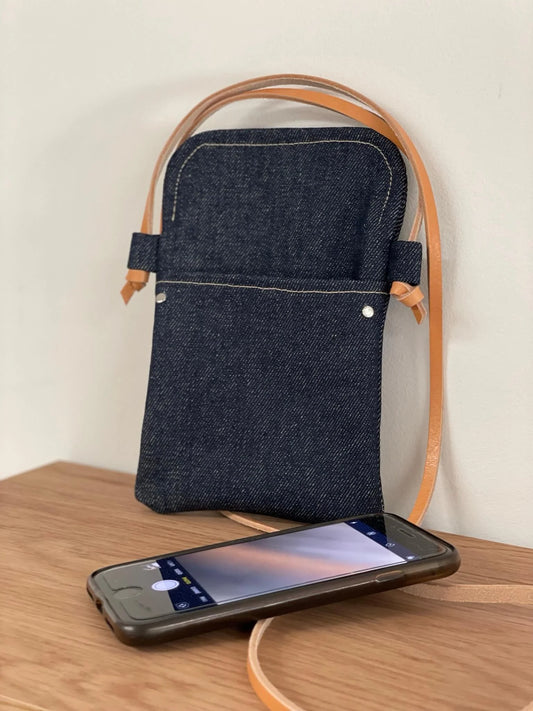 La pochette bandoulière téléphone en denim et cuir naturel.