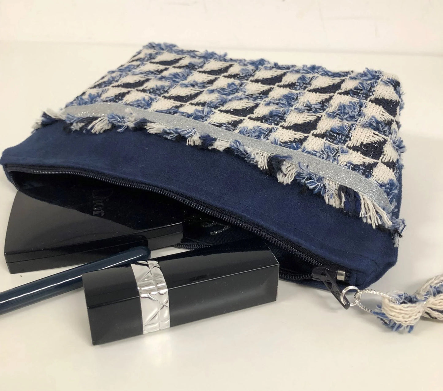 La pochette bleu et écru en tweed style haute couture française, présentée avec cosmétiques, non fournis.