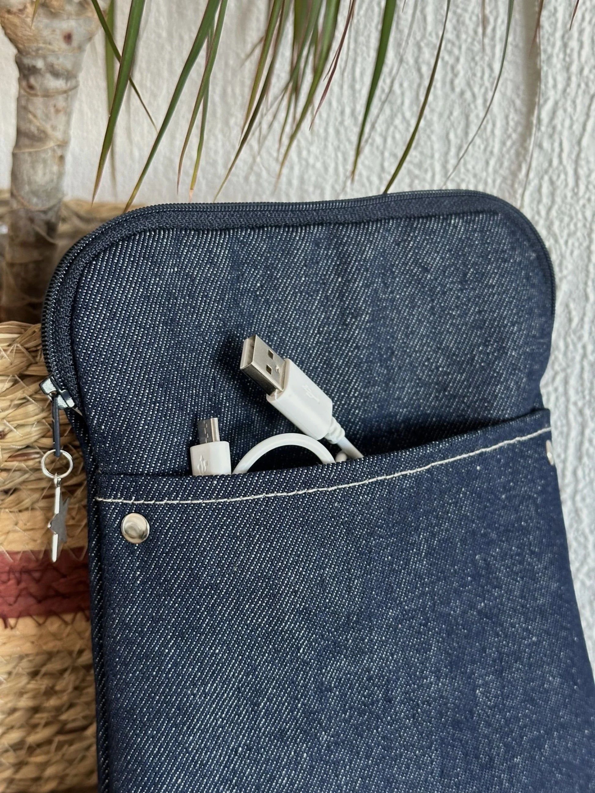 La poche avant de la pochette liseuse en denim brut.