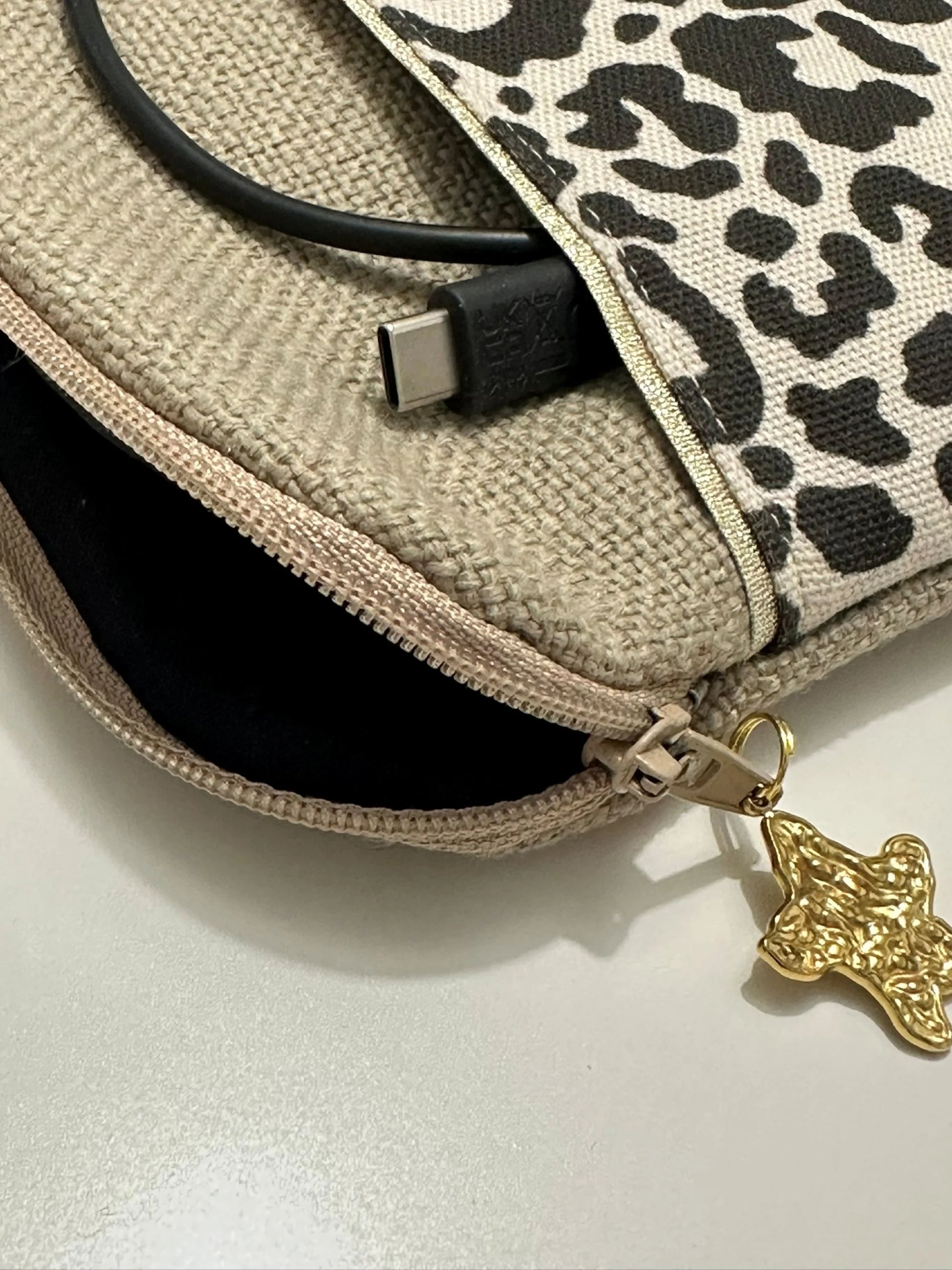 L'ouverture élargie de la pochette liseuse léopard en lin.