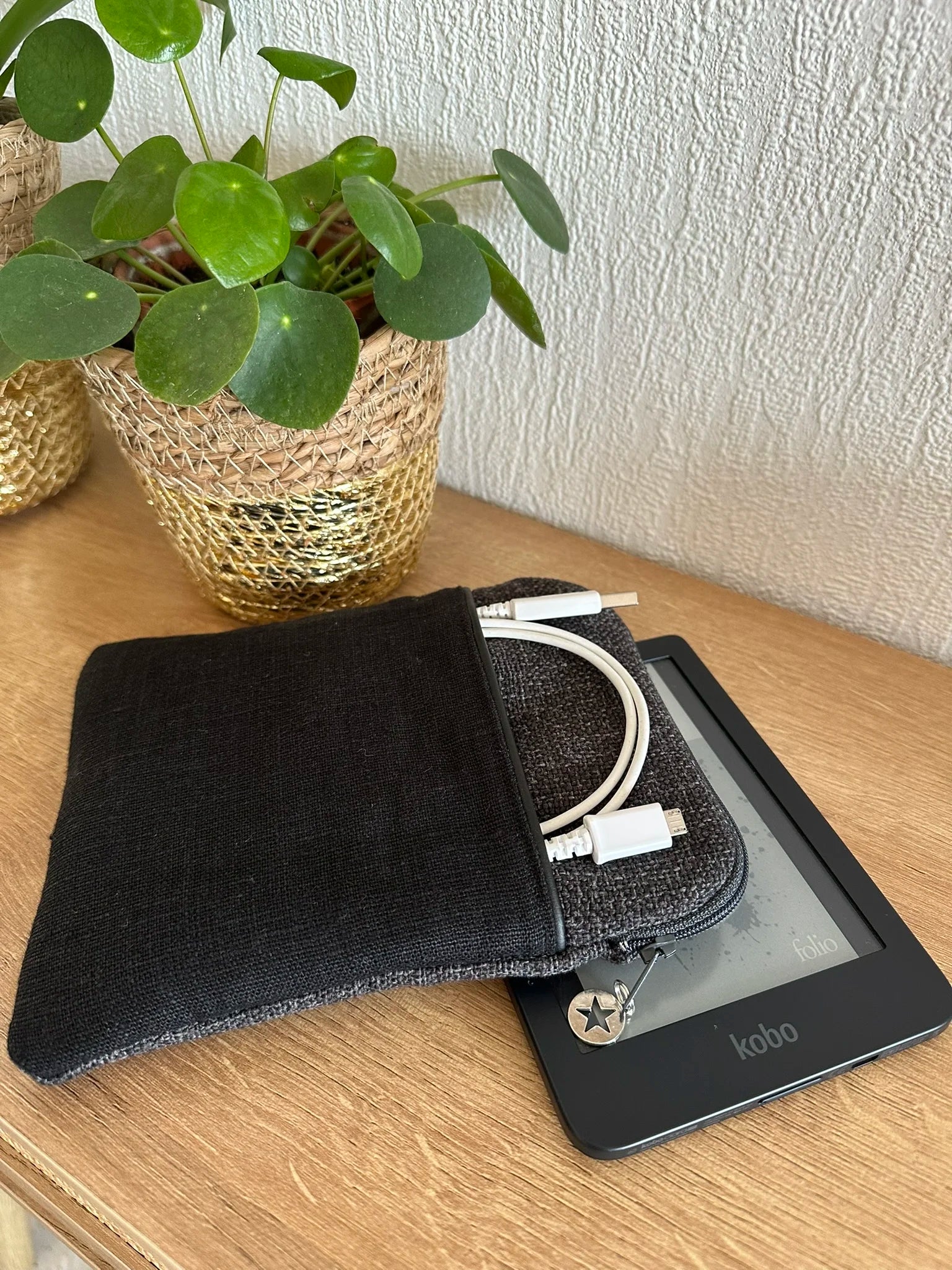 Vue latérale de la pochette liseuse unisexe en lin gris et noir.