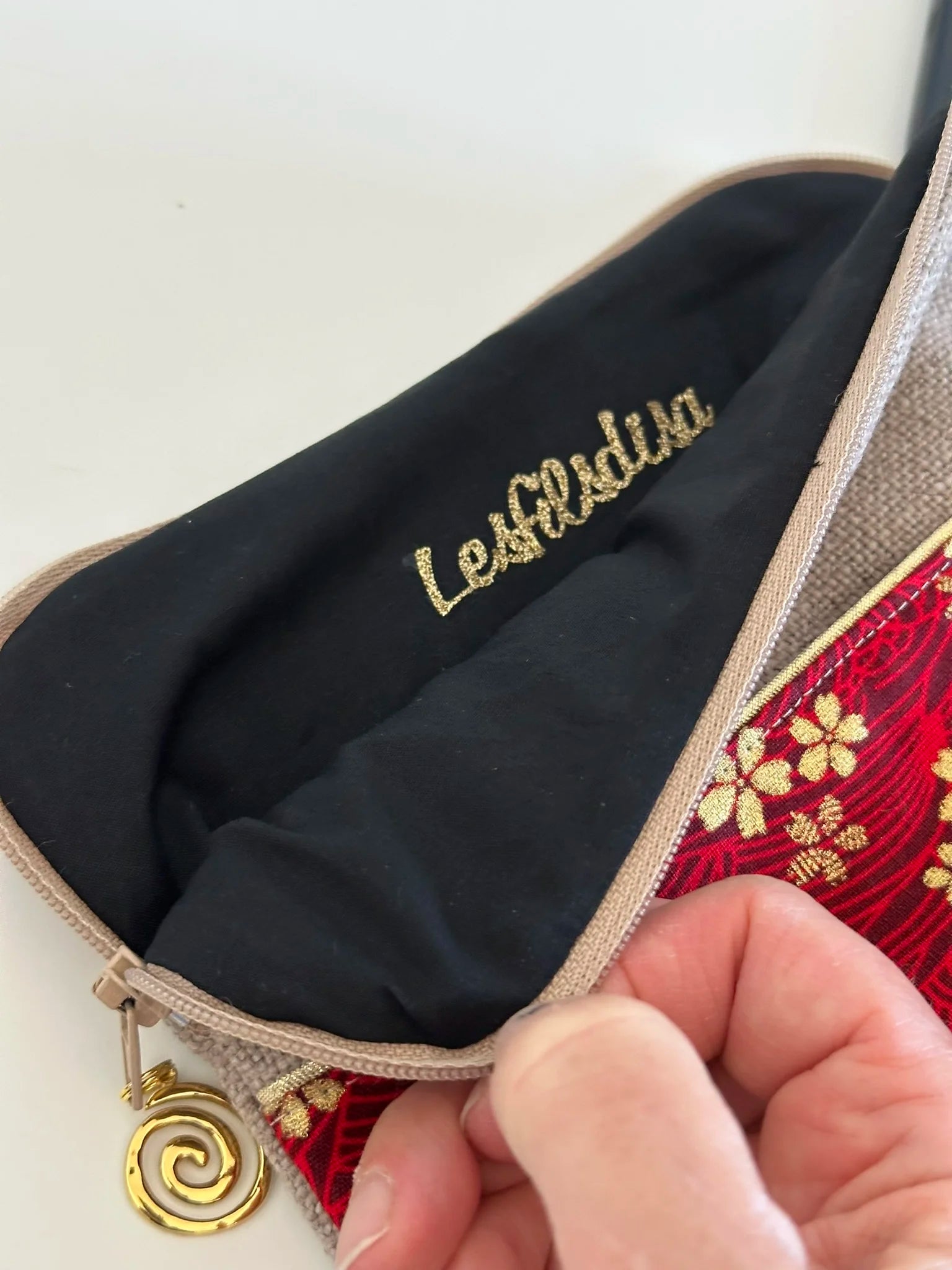 La doublure intérieure de la pochette liseuse en lin et tissu japonais Sakura rouge et doré.