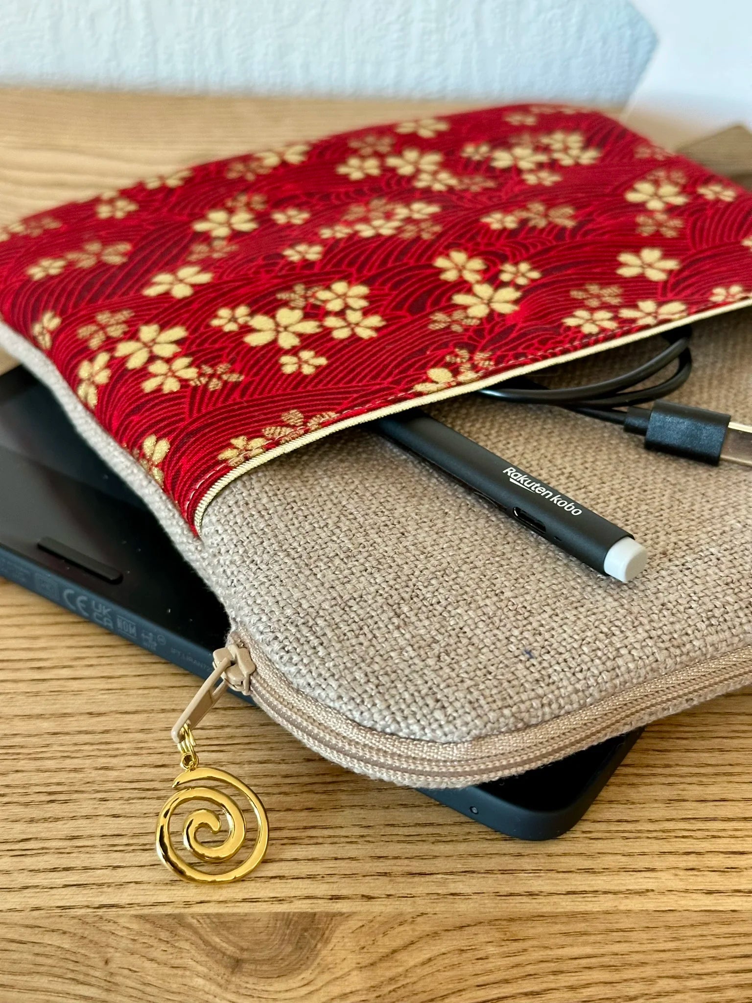 Vue détaillée de la fermeture zippée de la pochette liseuse en lin et tissu japonais Sakura rouge et doré.