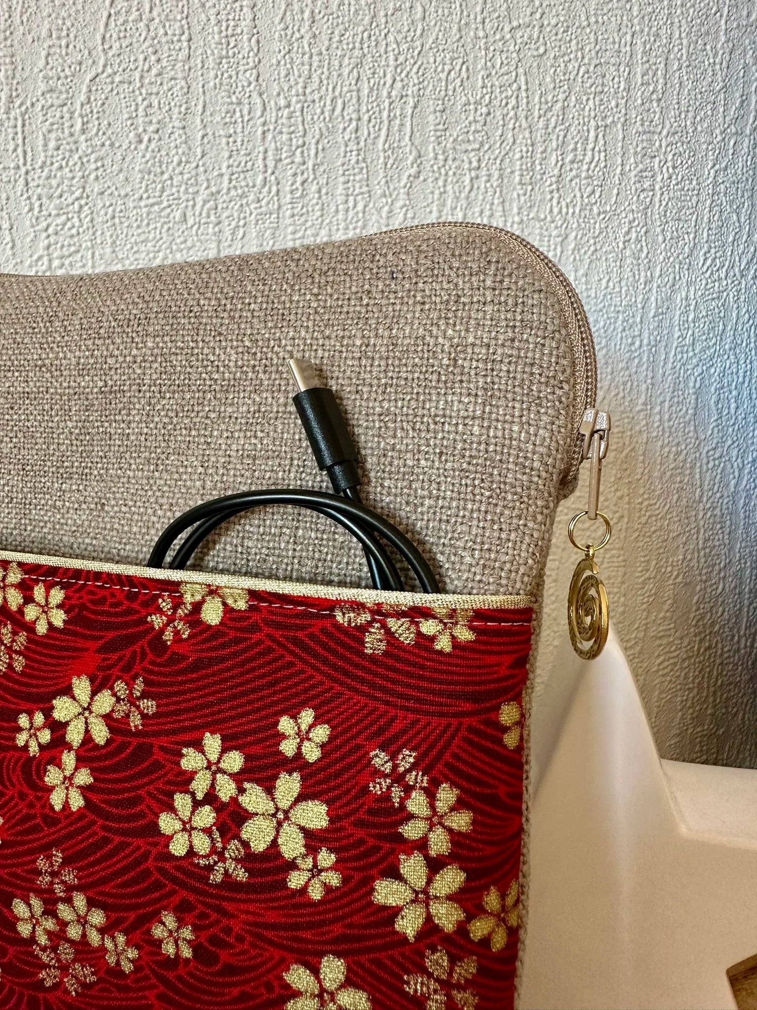 La poche avant de la pochette liseuse en lin et tissu japonais Sakura rouge et doré.