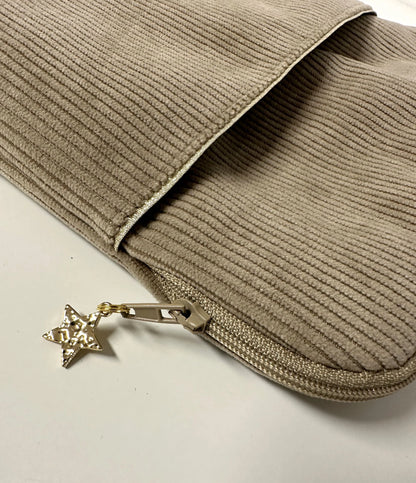 La poche avant de la pochette liseuse en velours cotelé beige.