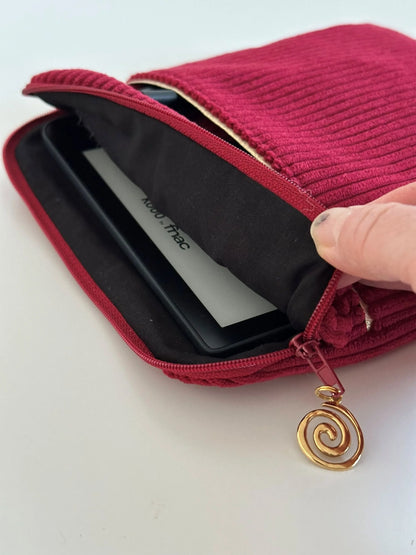 L'ouverture élargie de la pochette liseuse en velours cotelé bordeaux.