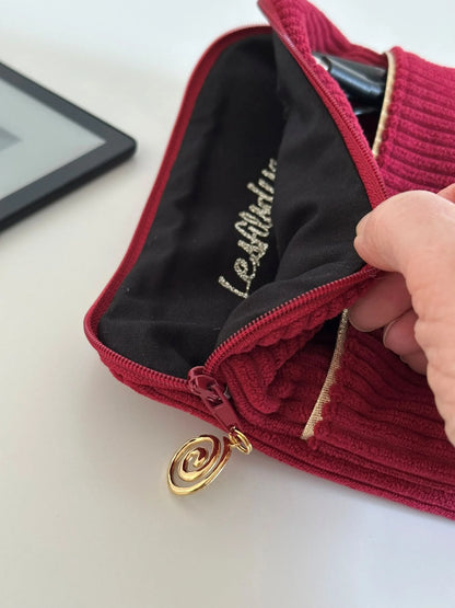 La doublure intérieure de la pochette liseuse en velours cotelé bordeaux.