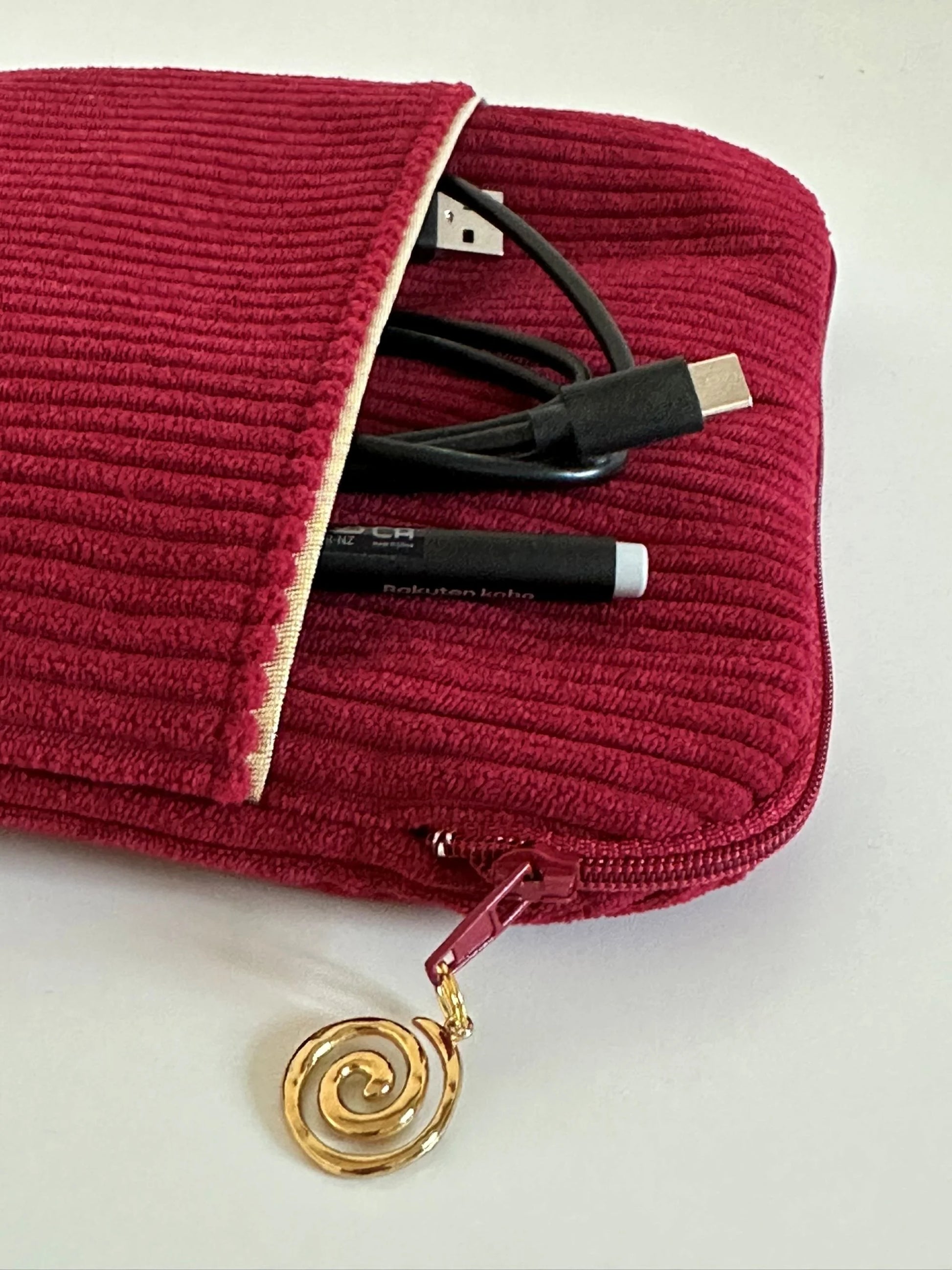 Vue détaillée du zip de la pochette liseuse en velours cotelé bordeaux.