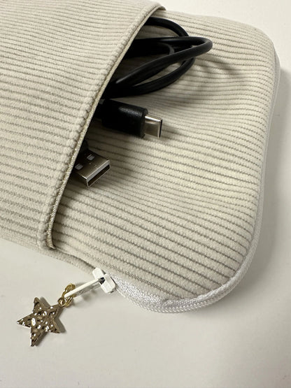 Le cable de recharge dans la poche avant de la pochette à liseuse en velours cotelé écru.