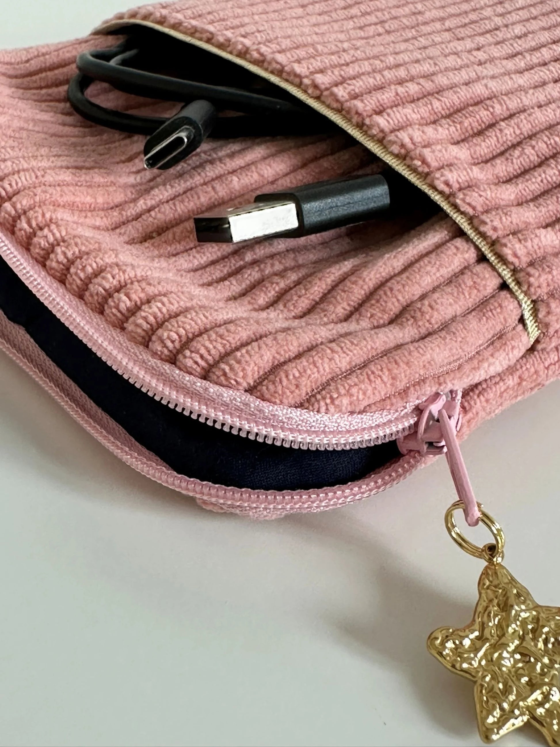 L'ouverture élargie de la pochette liseuse en velours cotelé rose blush .