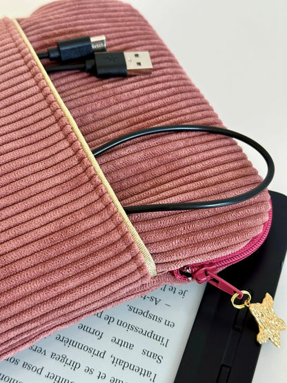 L'ouverture zippée élargie de la pochette liseuse en velours cotelé vieux rose.
