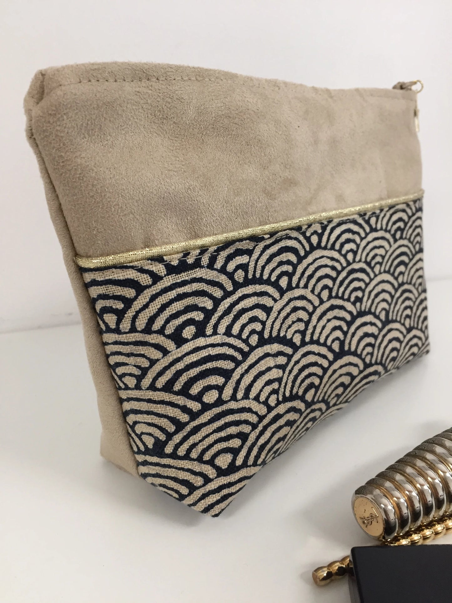 Vue latérale de la pochette à maquillage beige en tissu japonais Seigaiha bleu nuit.