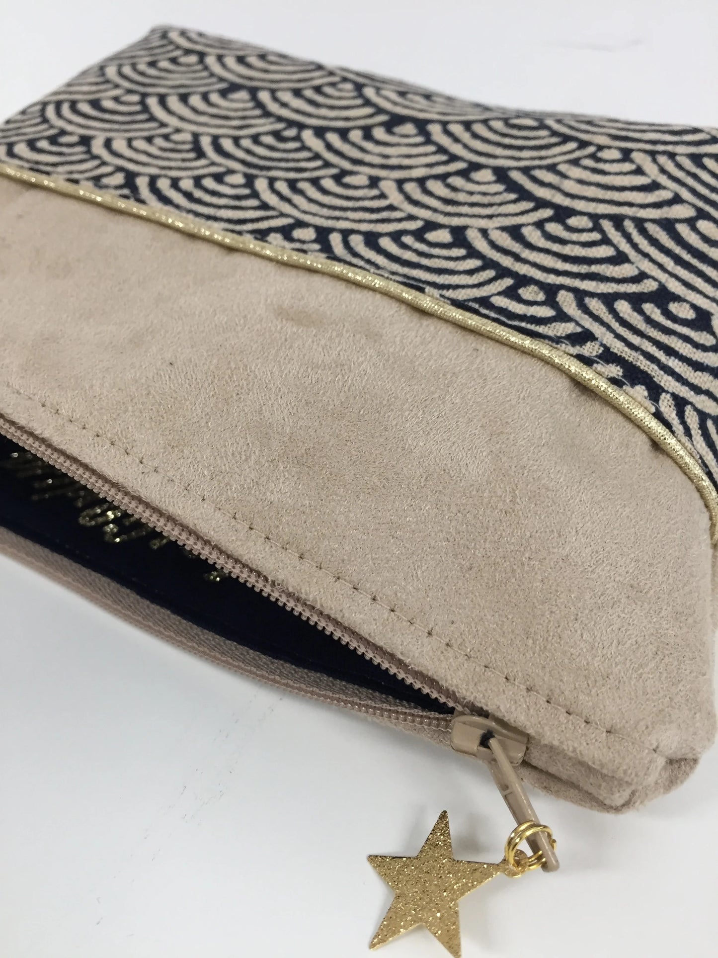 La pochette à maquillage beige en tissu japonais Seigaiha bleu nuit, entrouverte.