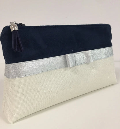 Face avant de la pochette à maquillage bleu marine et blanc à noeud argenté.