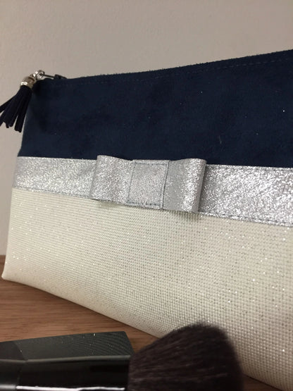 Le noeud de pochette à maquillage bleu marine et blanc à noeud argenté.