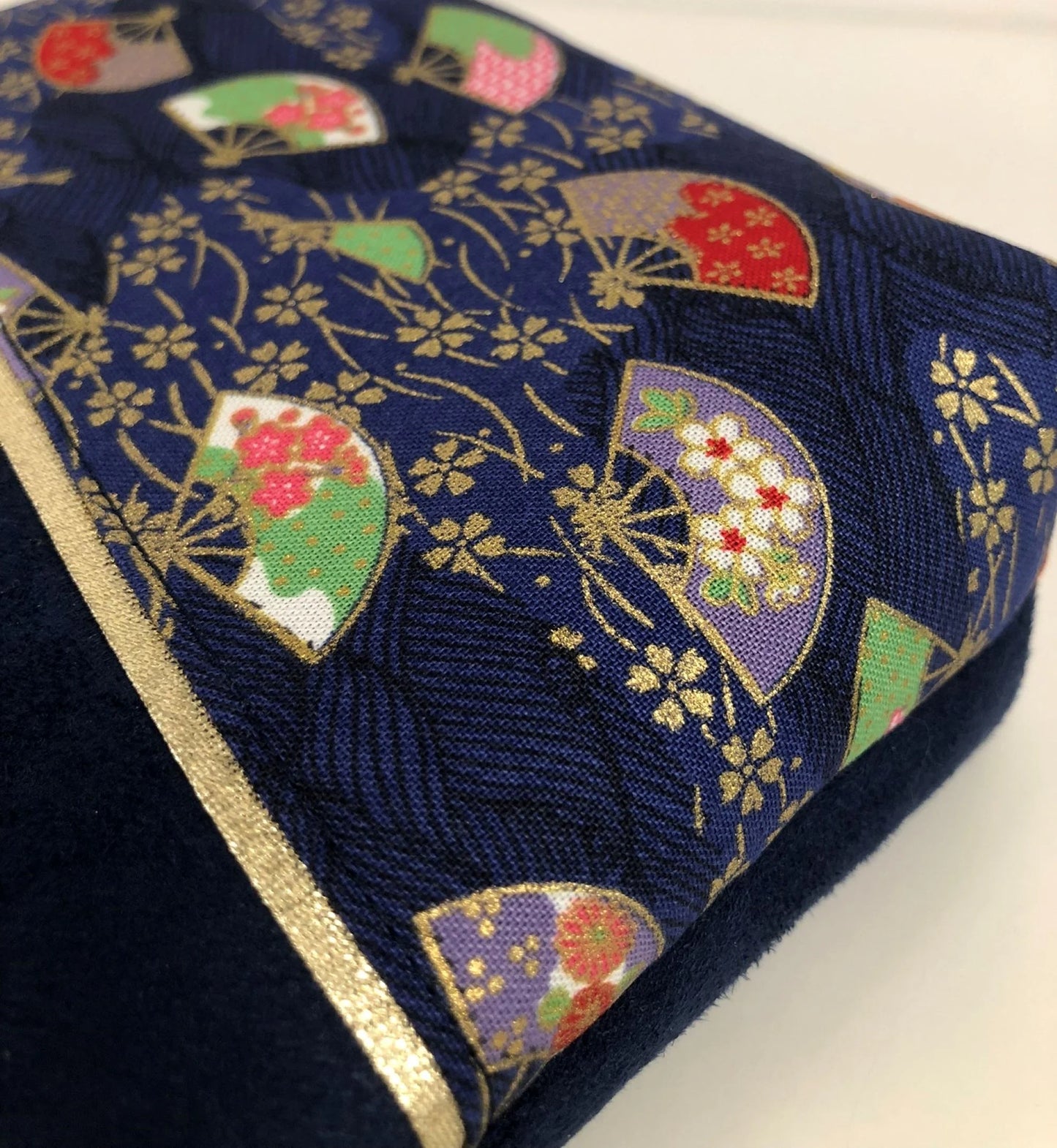 Vue détaillée du tissu japonais de la pochette à maquillage bleu marine en tissu japonais Sakura éventails.