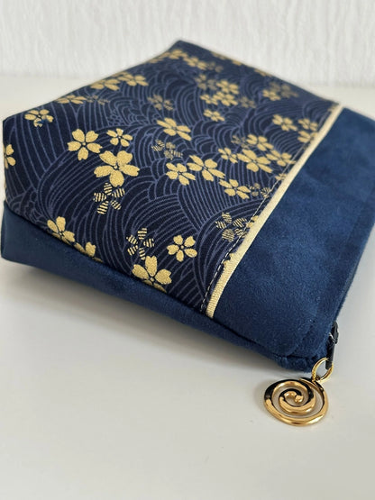 Vue latérale de la pochette à maquillage fleurie bleu et dorée.