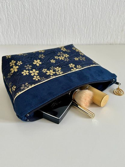 La pochette à maquillage fleurie bleu et dorée, ouverte.