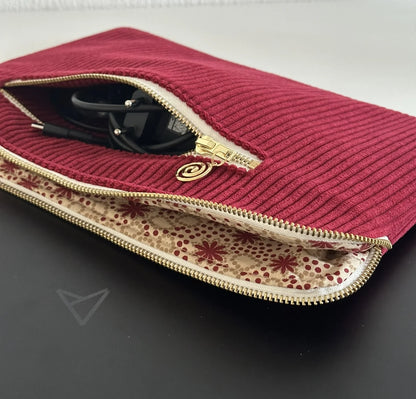 La doublure intérieure assortie de la pochette ordinateur en velours cotelé bordeaux.