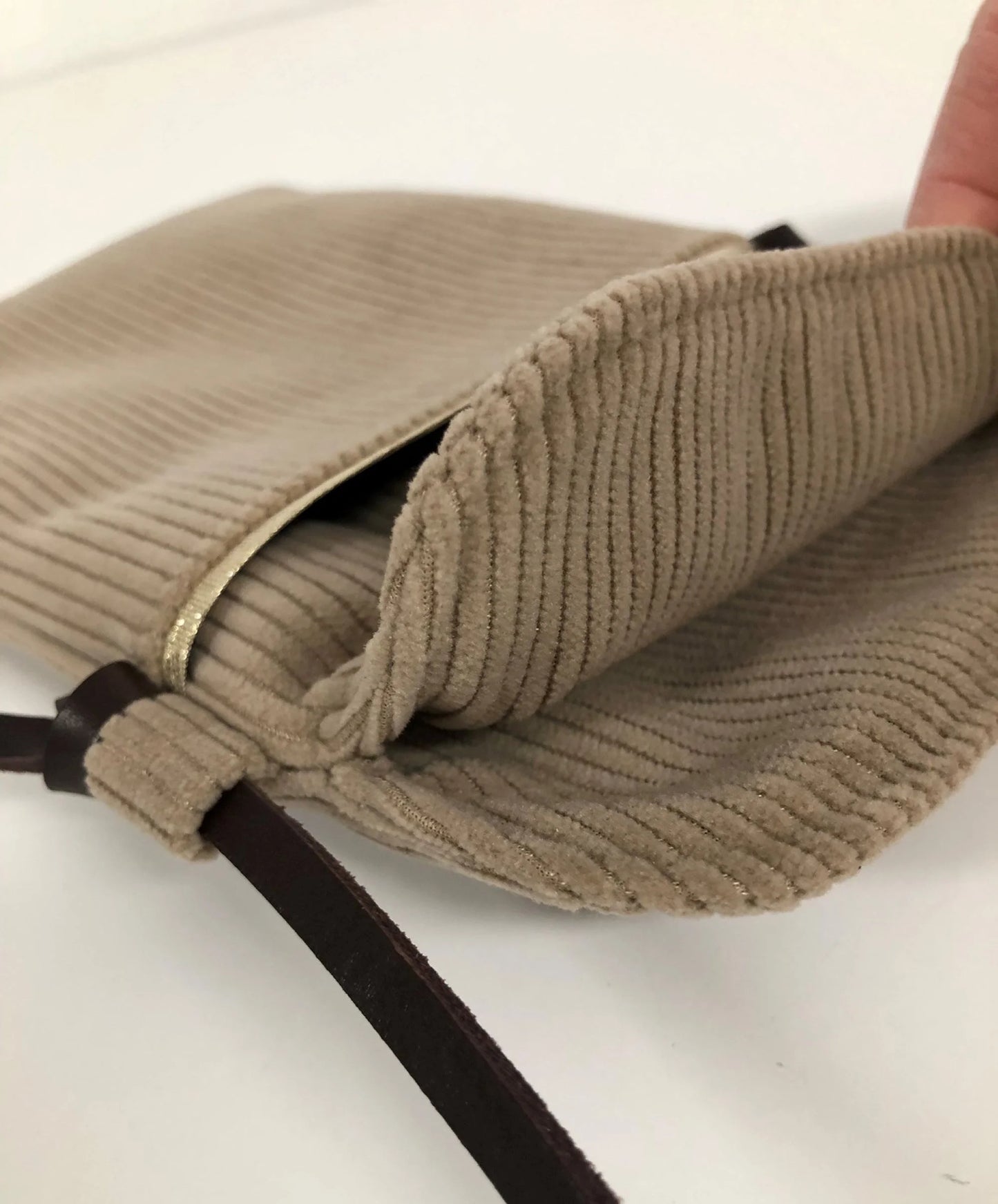 L'intérieur de la pochette téléphone bandoulière en velours cotelé beige.