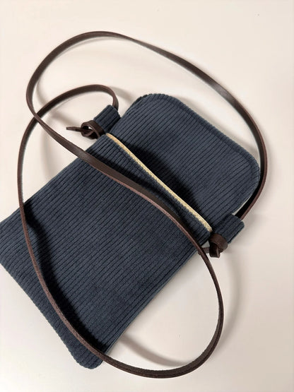 Vue d'ensemble de la pochette téléphone bandoulière en velours cotelé bleu canard.