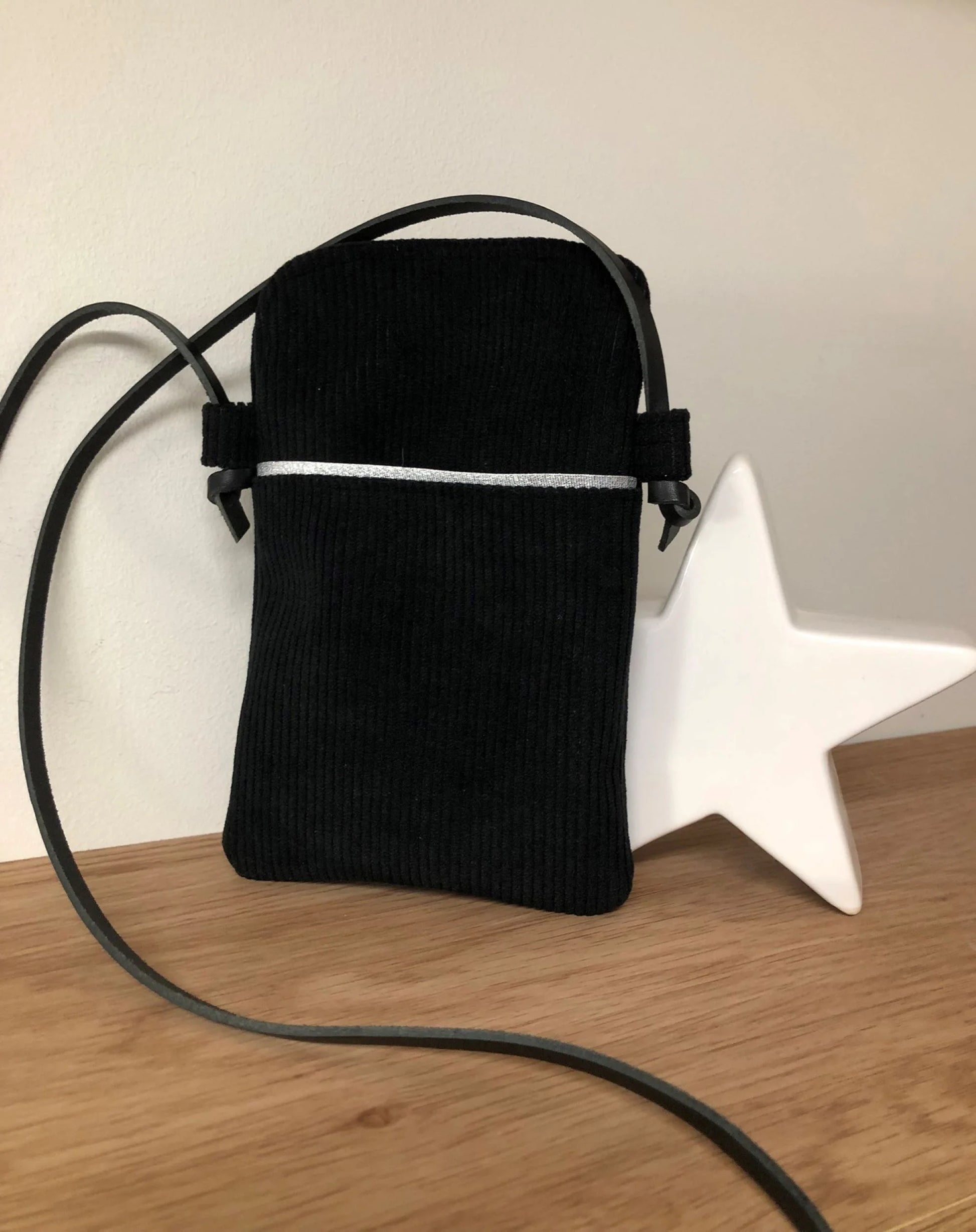 La pochette téléphone bandoulière en velours cotelé nloir et cuir, vue d'ensemble.