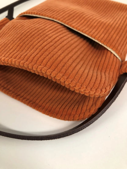 L'intérieur de la pochette téléphone bandoulière en velours cotelé orange.