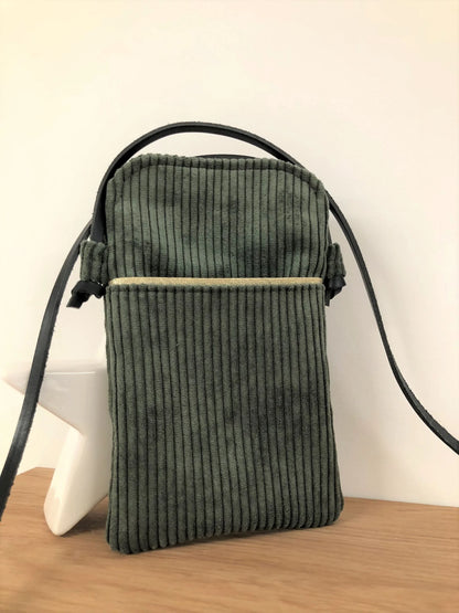 La pochette téléphone bandoulière en velours cotelé vert kaki et sa lanière en cuir marron.