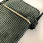 La poche avant de La pochette téléphone bandoulière en velours côtelé vert kaki et cuir 
