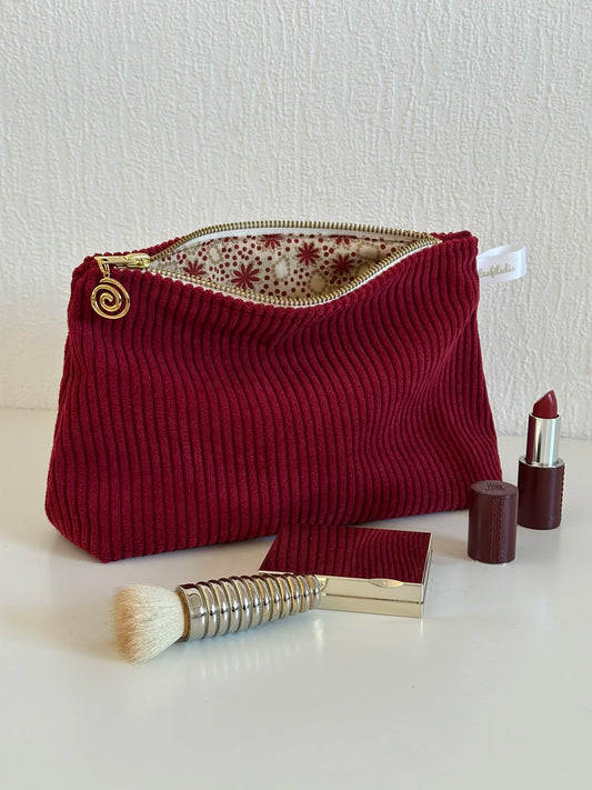 La pochette en velours cotelé bordeaux, ouverte.