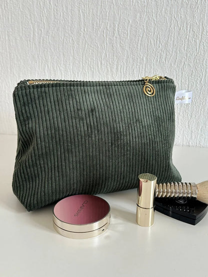 La pochette en velours côtelé vert kaki, fermée.