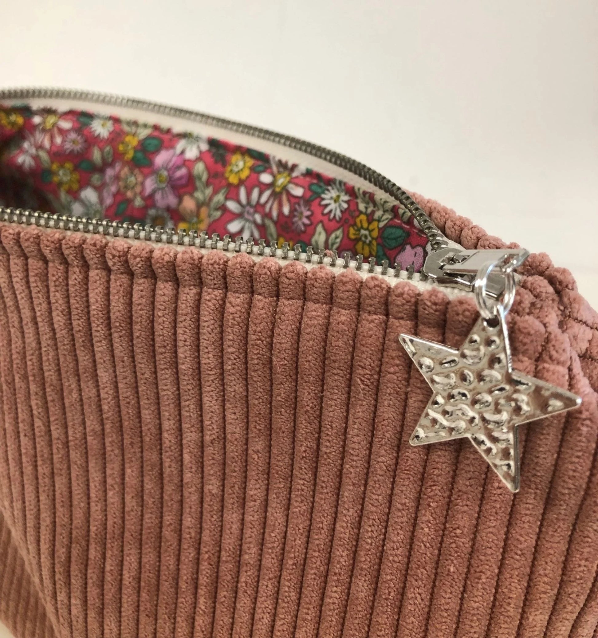 Le zip métal de la pochette en velours cotelé vieux rose.