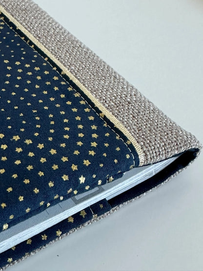 Vue détaillée du porte chéquier beige et bleu à étoiles dorées.